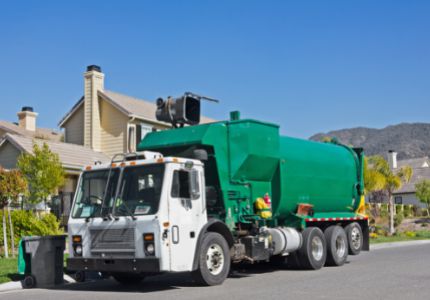 Hauler truck pouring curbside bin into truck