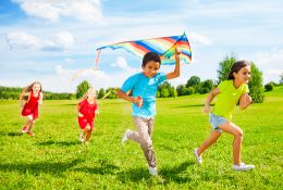 Children running in a field on a sunny day with clean air